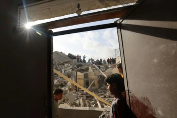 Des Palestiniens inspectent les ruines d'un immeuble détruit par une frappe israélienne, le 21 avril 2024 à Rafah, dans le sud de la bande de Gaza