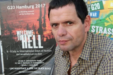 Andreas Blechschmidt, l'un des plus anciens activistes du "Rote Flora", devant une affiche "Bienvenue en Enfer", le 19 juin 2017 à Hambourg où se tiendra le sommet du G20 
