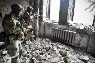 Des soldats russes patrouillent dans des bâtiments détruits à Marioupol, dans le sud-est de l'Ukraine, le 12 avril 2022