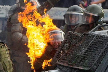 Une policière atteinte par un cocktail molotov pendant une manifestation à Santiago du Chili, le 4 novembre 2019