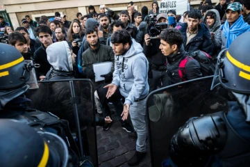 Des migrants face à des policiers lors d'une opération de contrôle le 31 octobre 2016 dans le nord de Paris