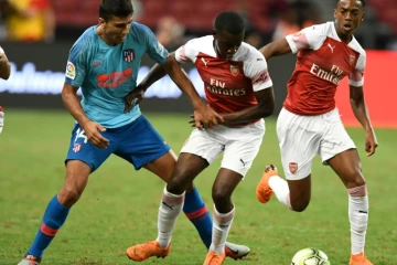 Le joueur de l'Atletico Madrid Rodri (g) à la lutte avec Eddie Nketiah (c), d'Arsenal, lors d'un match amical (international Champions cup) joué le 26 juillet 2018 à Singapour