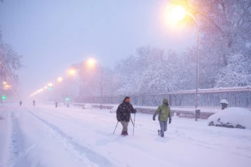 Des habitants de Madrid marchent dans la neige qui a recouvert les routes de la capitale espanole le 9 janvier 2021