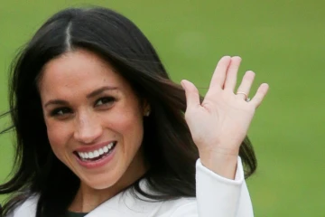 La fiancée du prince Harry Meghan Markle salue les photographes le 27 novembre 2017 dans les jardins du palais de Kensington à Londres