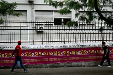 Des gens passent devant des affiches invitant à voter pour le référendum, à Rome, le 5 juin 2025
