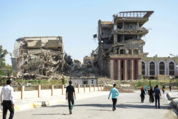 Des Irakiens marchent en direction de l'université de Mossoul le 13 juin 2017