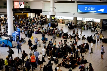 Des voyageurs attendent à l'aéroport de Gatwick alors que des vols sont annulés ou retardés en raison d'une panne informatique mondiale, le 19 juillet 2024 au Royaume-Uni