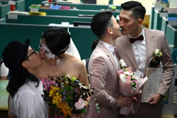 Les premiers couples homosexuels officiellement mariés s'embrassent, à Taipei, le 24 mai 2019