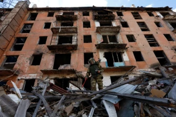 Un sapeur russe inspecte les décombres d'un bâtiment en ruine à Marioupol, le 19 avril 2024 en Ukraine sous contrôle russe