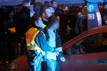 La police arrête un homme parmi ceux rassemblés devant la gare centrale de Cologne, la nuit de la Saint Sylvestre