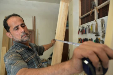 Le menuisier syrien Houssam Obeid dans son atelier de Saqba, dans la Ghouta orientale, près de Damas, le 13 août 2018