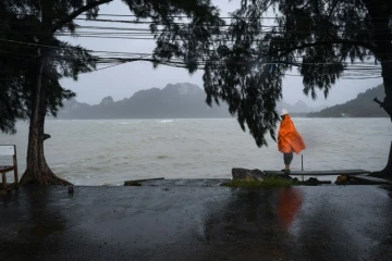 Un homme monte la garde, le 4 janvier 2019, sur un quai vide dans la région de Surat Thani, dans le sud de la Thaïlande, où tous les transports sont immobilisés avant l'arrivée de la tempête tropicale Pabuk