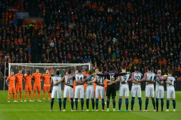 Les joueurs des Pays-Bas et de la France observent une minute de silence au début de leur match amical à Amsterdam, le 25 mars 2016
