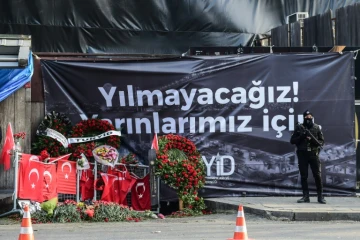 Un policier turc anti-émeute devant une banderole "pour notre avenir nous n'allons pas plier" dépliée, le 3 janvier 2017 à Istanbul devant la discothèque Reina 