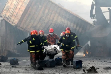 Des pompiers portent le corps d'une victime d'un incendie dans un entrepôt de conteneurs, le 5 juin 2022 à Sitakunda, au Bangladesh