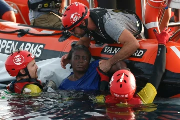 ARCHIVE - Des membres de l'ONG espagnole Proactiva Open Arms sauvent une migrante camerounaise (Josepha, 40 ans) en Méditerranée, à environ 140 km de la Libye, le 17 juillet 2018.