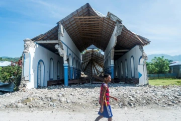 Un homme passe devant les décombres d'une église de la commune des Anglais (Haïti) le 14 août 2021