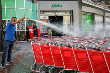 Un employé d'un supermarché palestinien désinfecte des chariots à Gaza le 21 septembre 2020