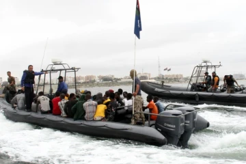 Des migrants dans un bateau des garde-côtes libyens après qu'ils ont été secourus au large de la ville de Qarabulli, à 60 km à l'est de Tripoli, le 7 septembre 2015