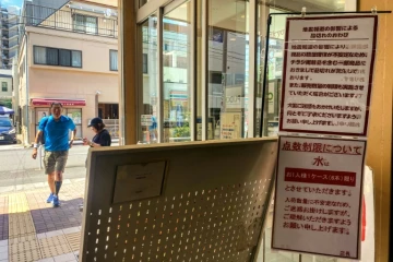 L'entrée d'un supermarché où des affiches indiquent des ruptures de stock pour certains produits et des restrictions de vente pour l'eau, le 10 août 2024 dans le district de Sumida, à Tokyo