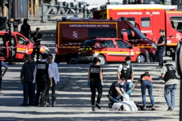 Des membres de la police judiciaire enveloppent le corps de l'auteur de l'attentat raté sur les Champs-Elysées à Paris, le 19 juin 2017
