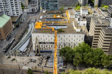 Des visiteurs sur une passerelle aérienne reliant les toits de bâtiments du centre-ville de Rotterdam, le 26 mai 2022 aux Pays-Bas