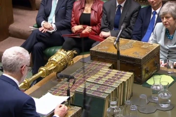 Capture écran d'une vidéo du Parlement britannique montrant Theresa May (d) écouter Jeremy Corbyn, à la Chambre des communes, le 25 mars 2019