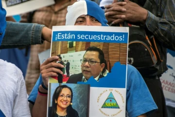 Un Nicaraguayen brandit une pancarte de soutien aux journalistes Miguel Mora et Lucia Pineda, accusés de terrorisme par le régime de Daniel Ortega, lors d'une manifestation le 22 décembre 2018 à San José au Costa Rica