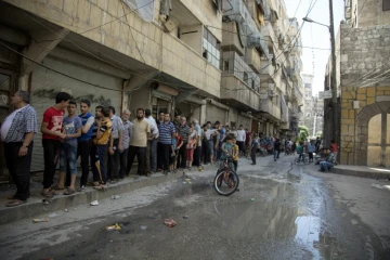 Des Syriens font la queue pour acheter du pain à Alep le 12 juillet 2016