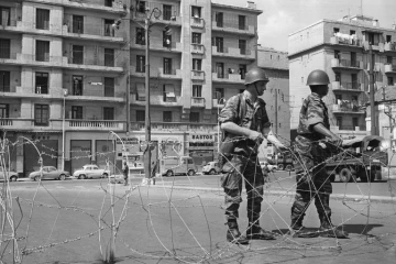 Des soldats ont procédé au bouclage du quartier européen d'Alger du "Champ de manoeuvres" et montent la garde devant les barbelés posés pour isoler le quartier le 04 mai 1962, après la signature des accords d'Evian