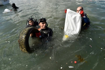 En équipement de plongée ou en tenue de plage, mains protégées par des gants, hommes, femmes et enfants se sont mués samedi 1er juillet 2017 en "éboueurs de la mer" sur une plage de l'est d'Alger jonchée de déchets.