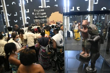 Des visiteurs découvrent des trésors restitués par la France au Bénin lors d'une exposition à Cotonou, le 20 février 2022