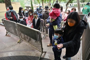 Des femmes et des enfants attendent pour se faire tester au Covid-19, le 23 février 2022 à Hong Kong