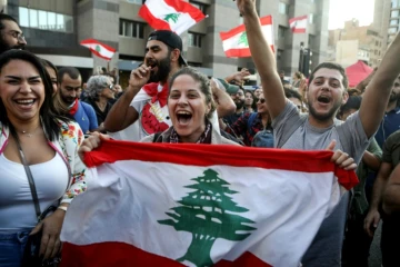 Les manifestants libanais célèbrent l'annonce de la démission du Premier ministre Saad Hariri, le 29 octobre 2019 à Beyrouth 