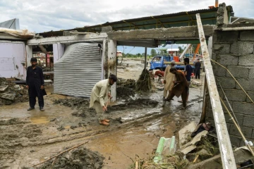 Des habitants tentent de dégager la boue qui a accompagné de violentes pluies de mousson, le 27 août 2022 à Mingora ( nord du Pakistan)
