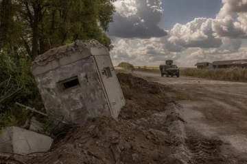 Un véhicule militaire blindé ukrainien passe devant un poste-frontière détruit avec la Russie, dans la région de Soumy, le 14 août 2024