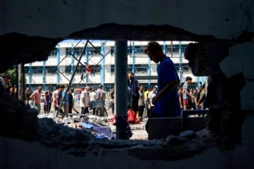 Des Palestiniens inspectent les dégâts à l'école Al-Razi gérée par l'ONU dans le camp de réfugiés de Nousseirat dans le centre de la bande de Gaza, après une frappe israélienne, le 16 juillet 2024
