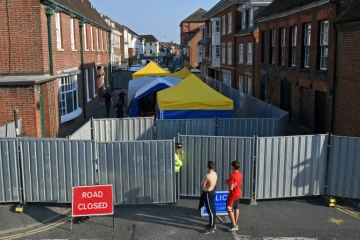 Un policier monte la garde le 5 juillet 2018 devant une barrière interdisant l'accès à une rue d'Amesbury, dans le sud de l'Angleterre, où un couple exposé au Novitchok est tombé malade