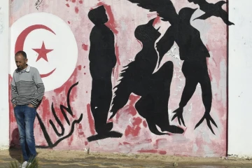 Un homme devant un graffiti que la place Mohamed Bouazizi, dans le centre de Sidi Bouzid, le 27 octobre 2020