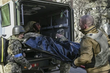 Des militaires ukrainiens évacuent le corps d'un soldat après une frappe russe, à Kiev, le 22 mars 2022