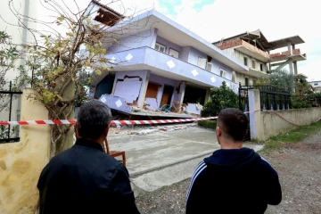 Des Albanais observent une maison effondrée le 28 novembre 2019 à Durres sur la côte Adriatique après un séisme meurtrier