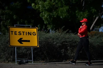 Des piétions passent devant un panneau indiquant un centre de dépistage au coronavirus à Southend-on-Sea, au Royaume Uni, le 19 septembre 2020