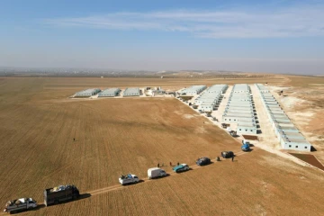 Vue aérienne d'un convoi de déplacés syriens arrivant au complexe résidentiel, construit près de la ville d'al-Bab, le 9 février 2022 en Syrie 
