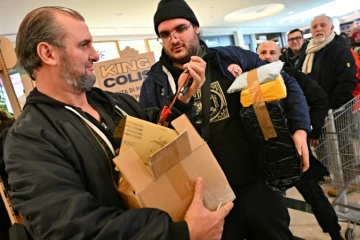 Des acheteurs lors d'une "vente à l'aveugle" de colis non réclamés, où les boîtes de toutes tailles sont vendues au poids dans un centre commercial de Rome, le 17 janvier 2025 