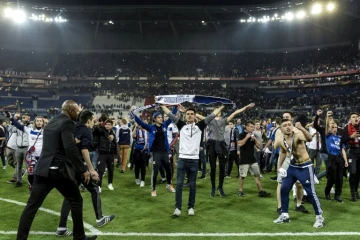 Des supporters lyonnais du Virage Sud envahissent la pelouse pour échapper à des jets de projectiles de supporters turcs, le 13 avril 2017 au Parc OL