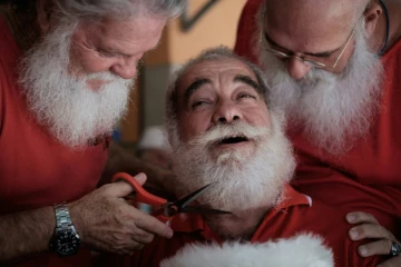 Un diplômé de l'Ecole de Père Noël brésilienne se fait tailler la barbe par un autre élève à Rio de Janeiro, le 28 décembre 2015