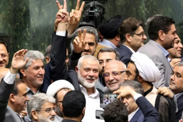 Le chef du Hamas Ismaïl Haniyeh (C) fait le signe de la victoire lors de la cérémonie de prestation de serment du nouveau président iranien, au parlement de Téhéran, le 30 juillet 2024
