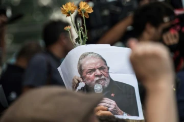 Un partisan de Lula arbore une photo de l'ex-président le 7 avril 2018 au cours d'une messe à la mémoire de son épouse.