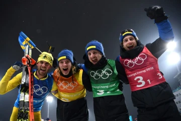 (g à d) Les Suédois Fredrik Lindstroem, Sebastian Samuelsson, Jesper Nelin et Peppe Femling célèbrent leur victoire au relais 4x7,5 km du biathlon, à Pyeongchang, le 23 février 2018