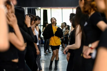 Pham Kieu Ly (C) explique à ses élèves comment prendre la pose pour se photographier avec leur téléphone portable, dans un studio à Hanoï le 2 mars 2021